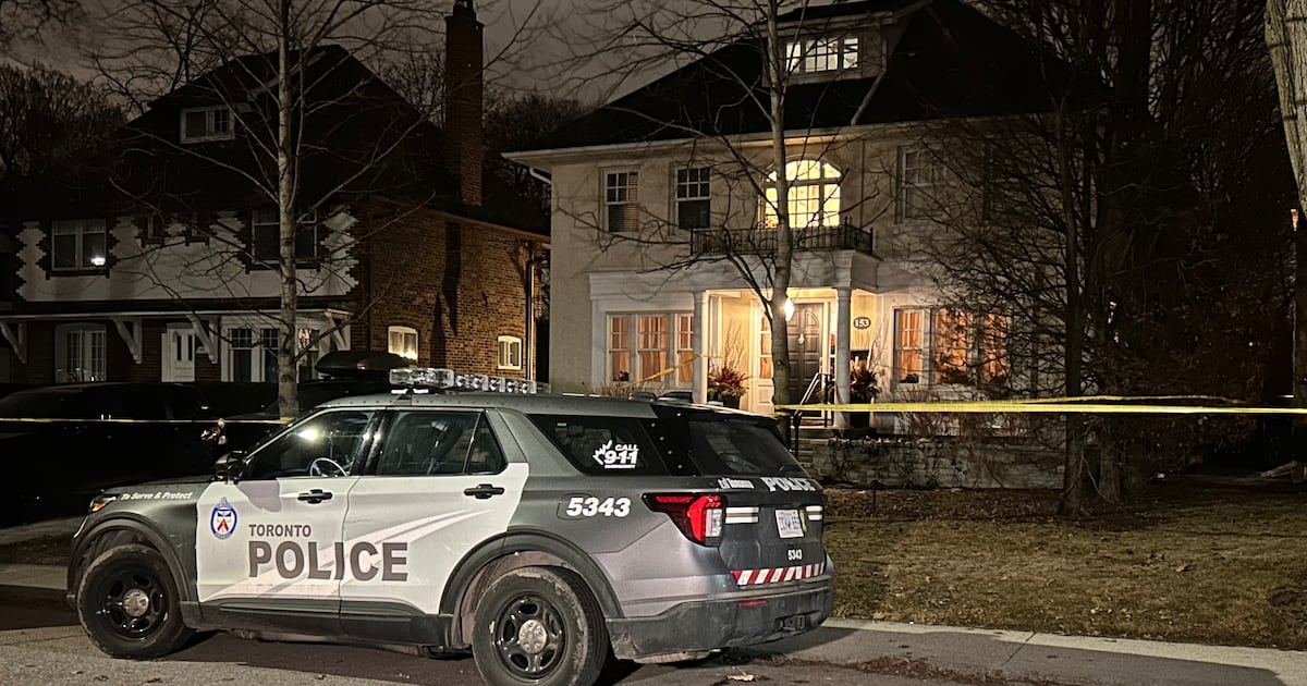 Police tape and emergency vehicles at the scene of the Toronto home invasion.